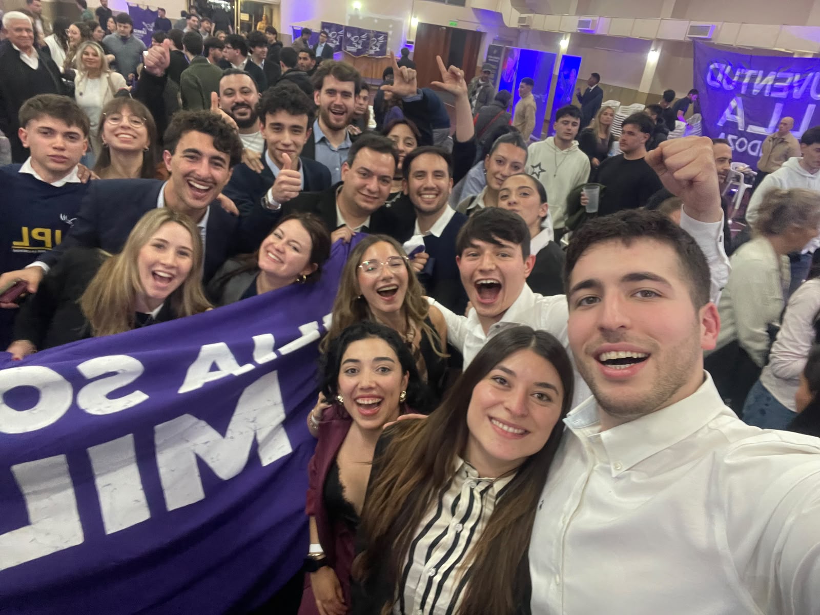 Militantes de la Juventud La Libertad Avanza Mendoza y de UPL celebrando juntos con una bandera violeta